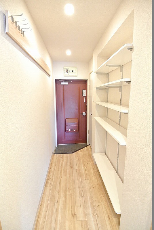 玄関から居間への廊下に靴を収納できる収納棚を設置しました。壁には長押を設置。